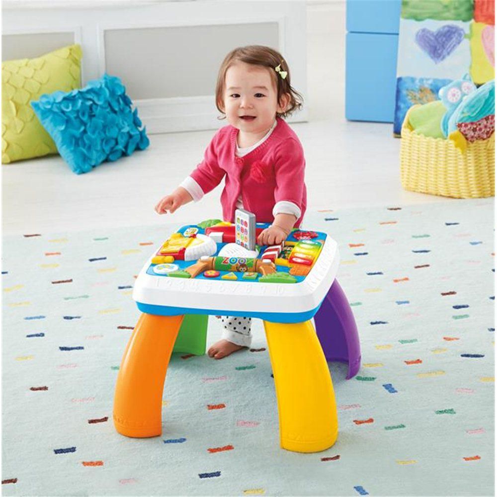 Dziewczynka z zabawką interaktywną - edukacyjnym stolikiem